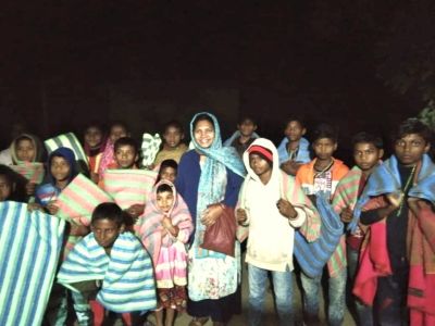 Rose, center in blue, with village children.